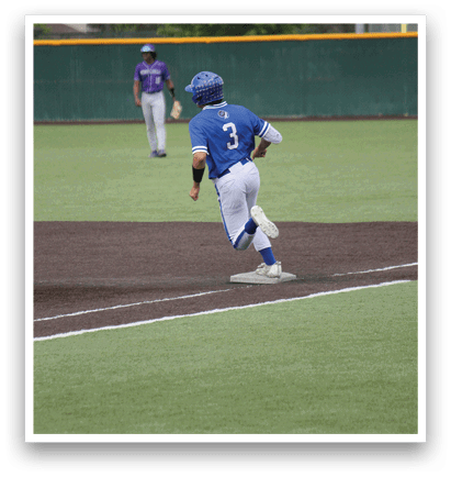 A baseball player wearing a blue shirt and white pants is running to first base. Description generated by AI