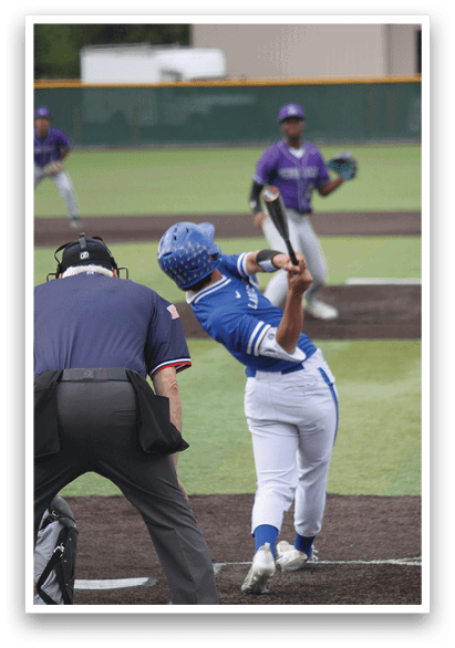 A baseball player in a blue and white uniform is holding a bat and getting ready to swing. Description generated by AI