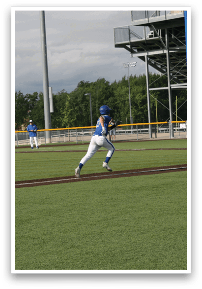A baseball player in a blue shirt and white pants is running towards a base. Description generated by AI