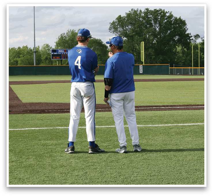 Two men standing on a baseball field. Description generated by AI
