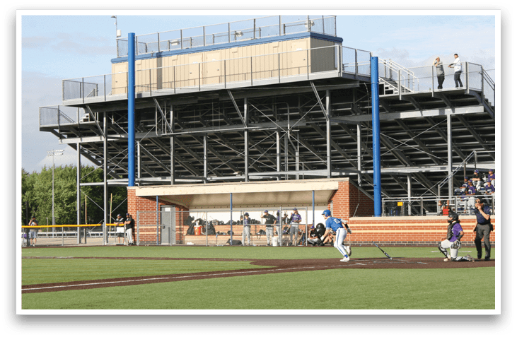 A baseball game is taking place on a field with a large stadium in the background. Description generated by AI