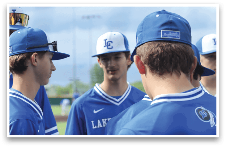 A group of young men wearing blue baseball caps and shirts. Description generated by AI