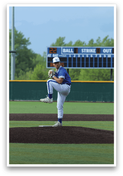 A baseball player in a blue and white uniform is pitching a ball. Description generated by AI