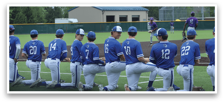Baseball players in blue uniforms kneeling on the field. Description generated by AI