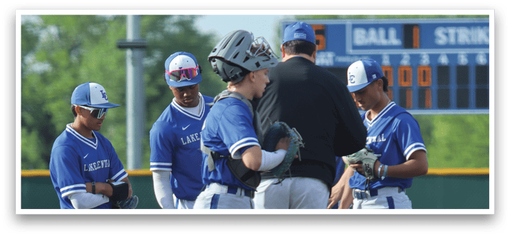 A group of baseball players wearing blue and white uniforms. Description generated by AI