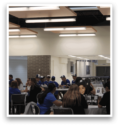 A group of people sitting at a table in a room. Description generated by AI