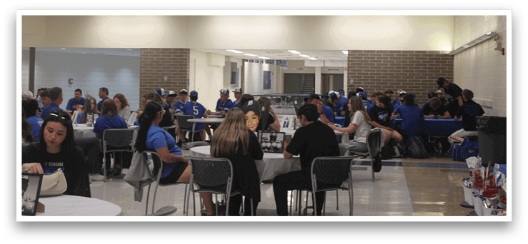 A group of people sitting at tables in a room. Description generated by AI