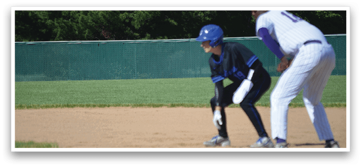 A baseball player in a black shirt and blue helmet is running to a base. Description generated by AI