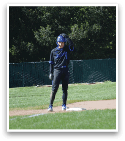 A person wearing a blue helmet and black uniform is standing on a baseball field. Description generated by AI