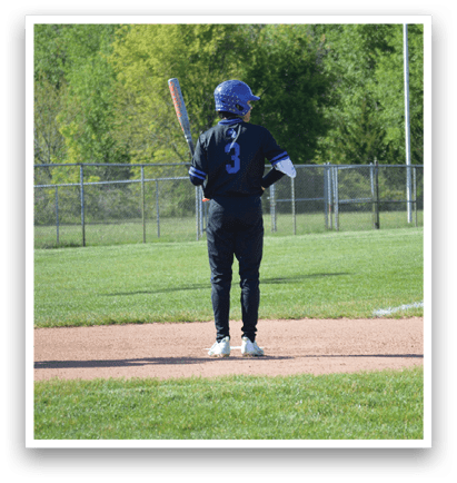 A baseball player is standing on the field with a bat. Description generated by AI