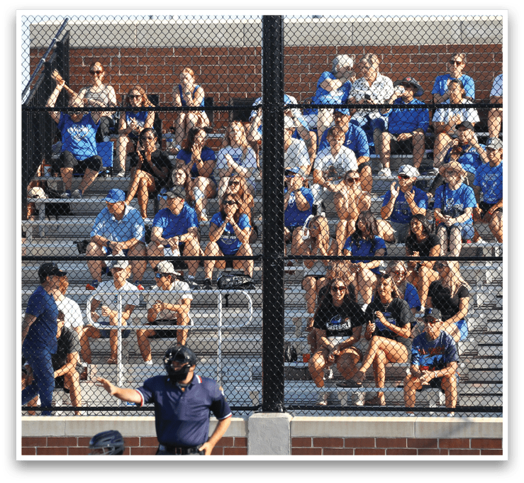 A crowd of people sitting on bleachers. Description generated by AI