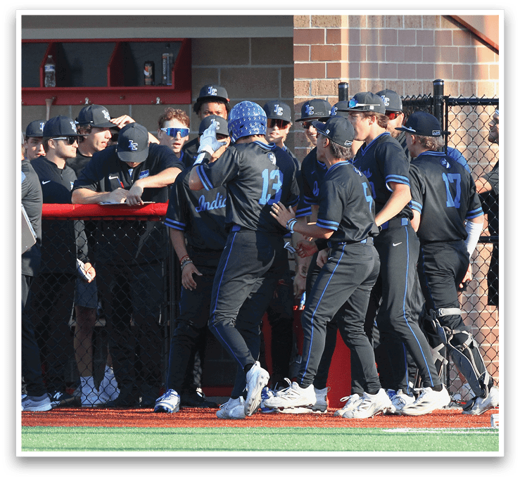 A group of baseball players wearing blue and black uniforms. Description generated by AI
