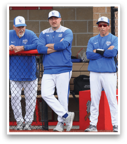 A group of men wearing blue shirts and white pants. Description generated by AI