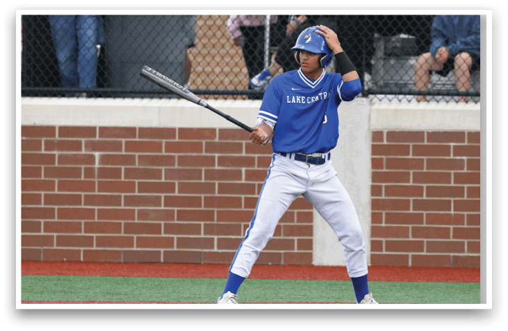 A baseball player in a blue uniform holding a bat. Description generated by AI