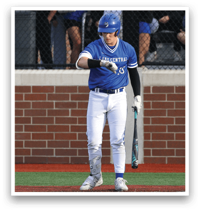 A baseball player in a blue and white uniform holding a bat. Description generated by AI