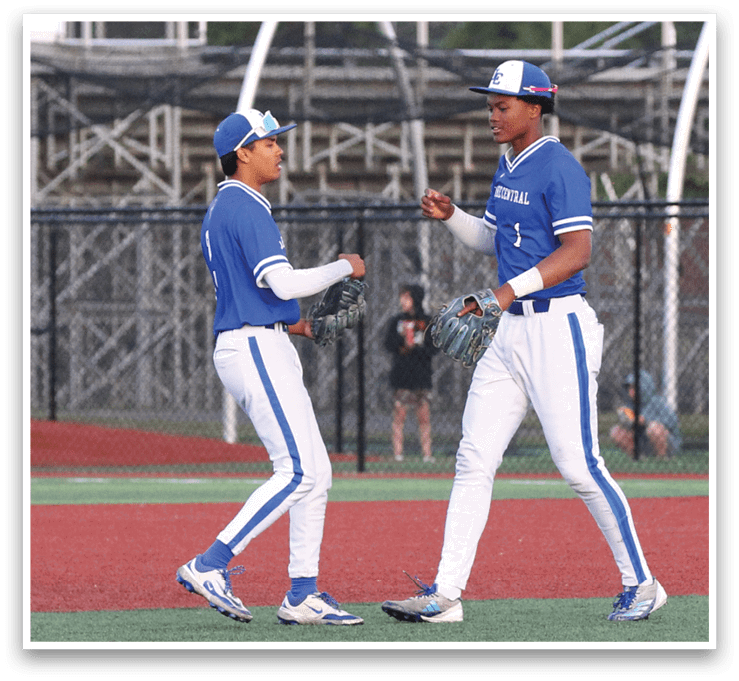 Two baseball players wearing blue and white uniforms. Description generated by AI