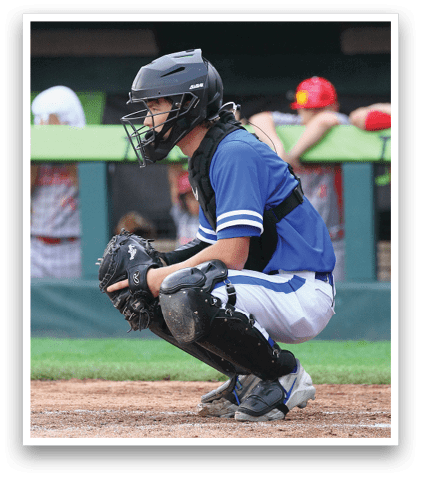 A baseball player in a blue shirt and black helmet is kneeling on the field. Description generated by AI