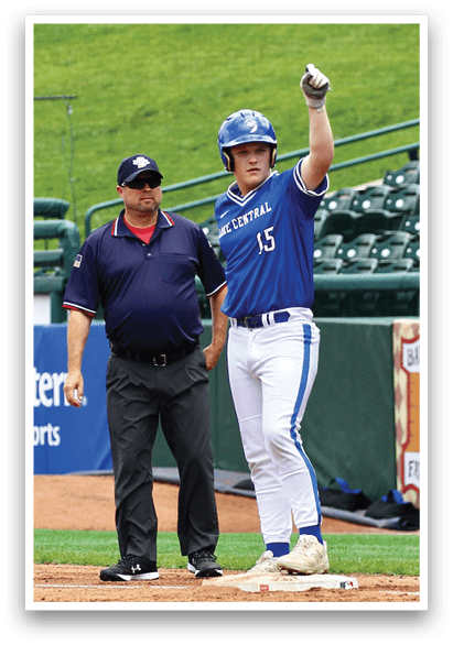 A baseball player wearing a blue and white uniform is pointing at the umpire. Description generated by AI