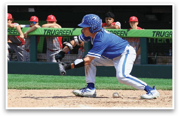 A baseball player in a blue uniform is bending over to catch a ball. Description generated by AI