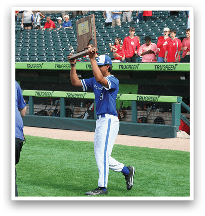 A man holding a trophy on a baseball field. Description generated by AI