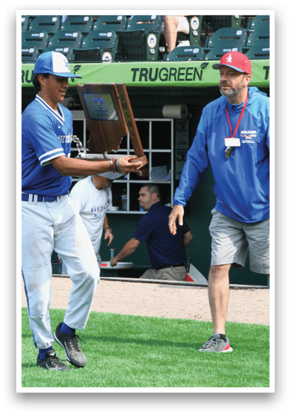 A man in a blue shirt holds a trophy. Description generated by AI