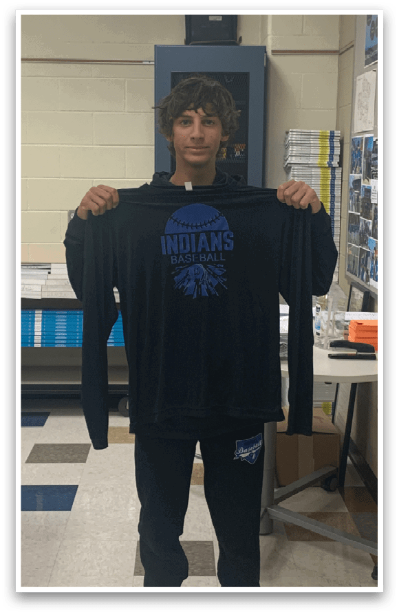 A man wearing a black shirt with the word Indians on it. Description generated by AI