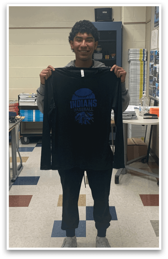 A man wearing a black shirt with the word Indians on it. Description generated by AI