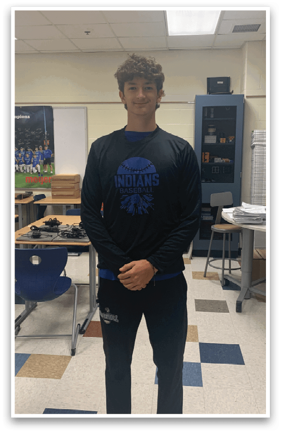 A man wearing a black shirt with the word Indians on it. Description generated by AI