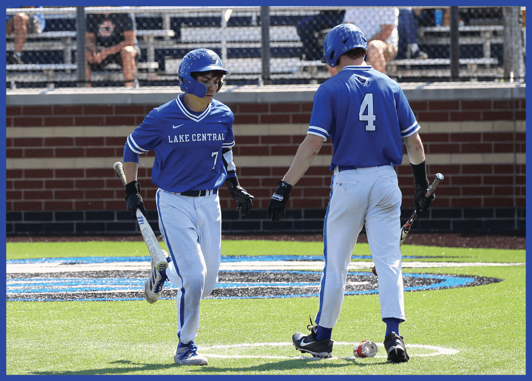 Two baseball players wearing blue and white uniforms. Description generated by AI