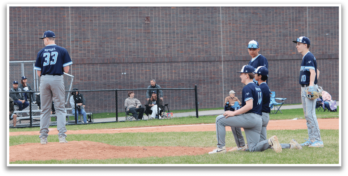 A baseball game is taking place with a pitcher on the mound and a batter at the plate. The pitcher is winding up to throw the ball, while the batter is ready to swing. There are several other players on the field, some of them wearing baseball gloves. A bench can be seen in the background, likely for the players to sit on when they are not actively participating in the game. AI generated content