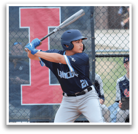 A baseball player is at bat, holding a bat and preparing to swing. The player is wearing a blue helmet and a blue shirt. There are several other people in the scene, some of whom are sitting on a bench and watching the game. AI generated content