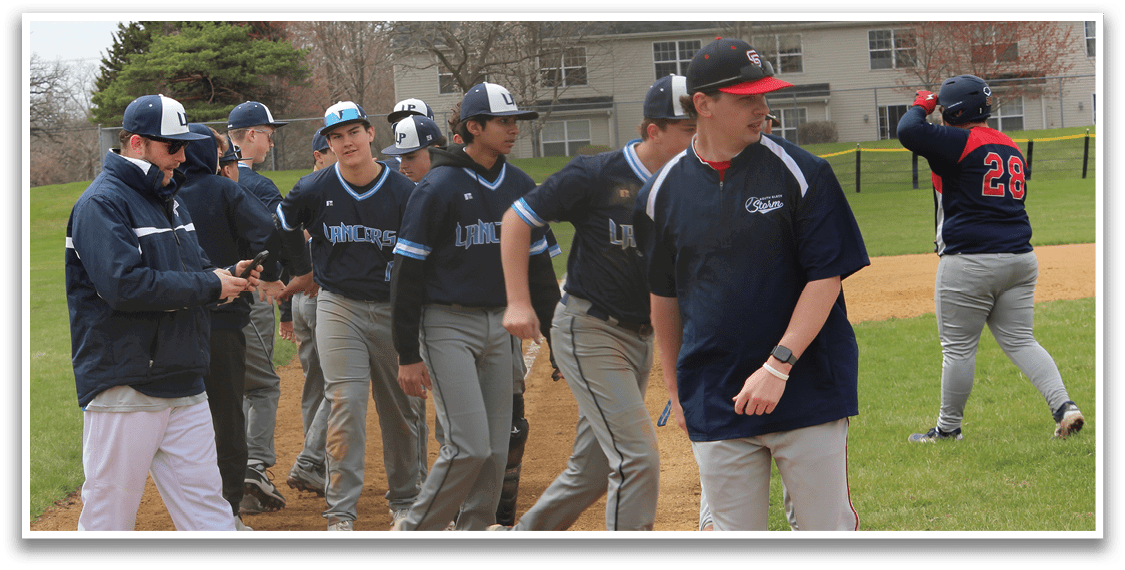 A group of baseball players are standing on a field, some of them wearing blue shirts. They are engaged in a conversation, possibly discussing the game or strategizing. The players are spread out across the field, with some standing closer to the foreground and others further in the background. The scene captures the camaraderie and teamwork often found in sports. AI generated content