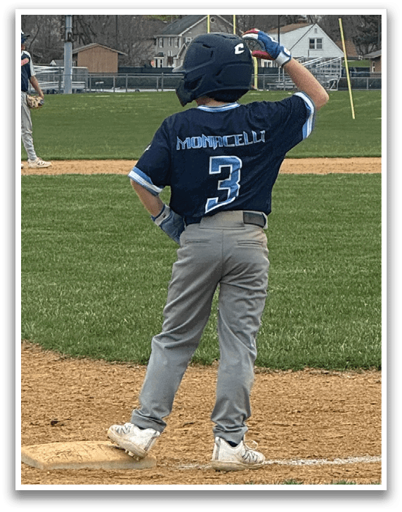 A young boy is standing on a baseball field, holding a bat and getting ready to hit the ball. AI generated content