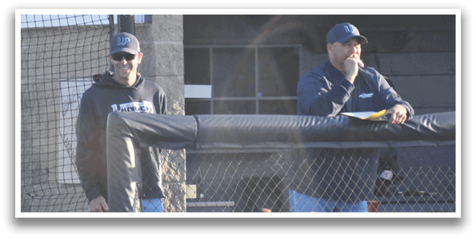Two men standing next to a fence with baseball bats. AI generated content