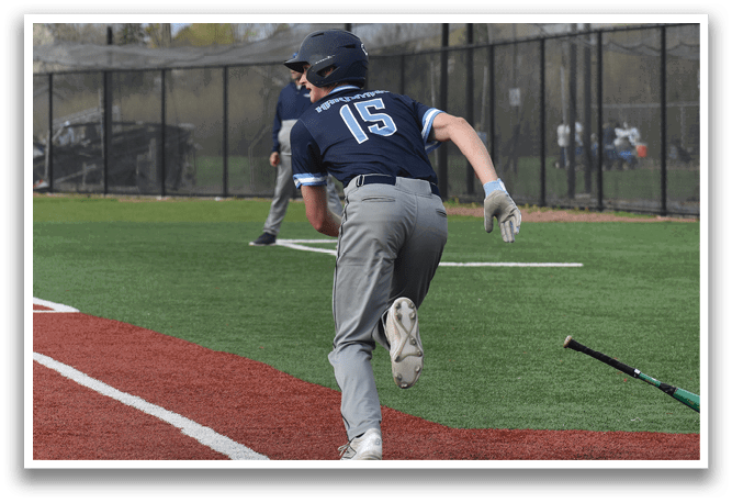 A baseball player in a blue shirt and grey pants is running towards home plate. AI generated content