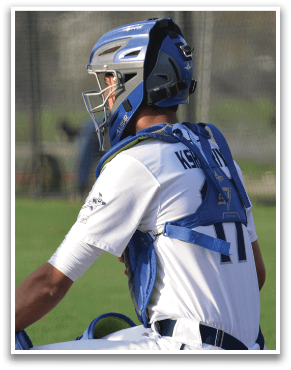 A baseball player wearing a helmet and a blue and white uniform is sitting on the ground. AI generated content