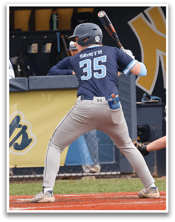 A baseball game is in progress with a batter at home plate, holding a bat and preparing to swing. The catcher is positioned behind the batter, wearing a baseball glove. There are several other players on the field, some of them standing in the dugout. The scene is set in a baseball field, with a bench visible in the background. AI generated content