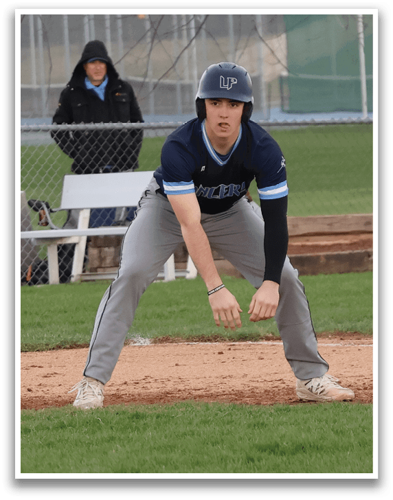 A baseball player in a blue shirt and grey pants is swinging a bat on a baseball field. AI generated content