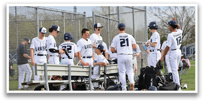 A group of baseball players are standing around a bench, talking and laughing. They are wearing their uniforms and holding baseball bats. AI generated content