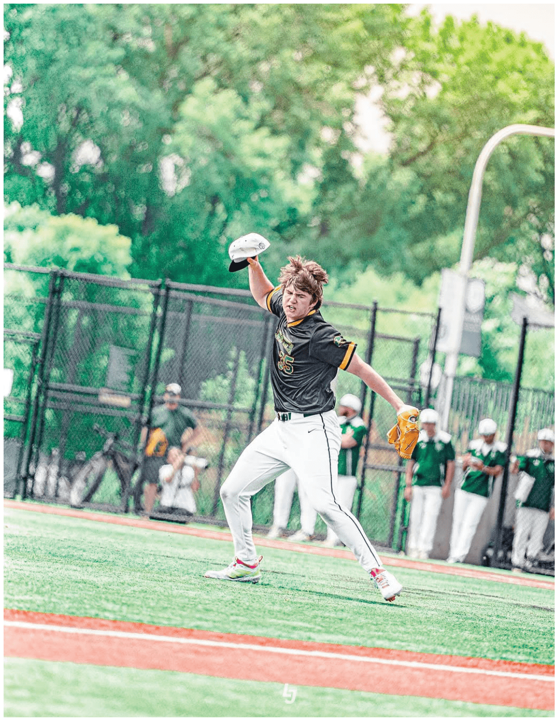 A baseball player with a black shirt and yellow letters on it. Description generated by AI
