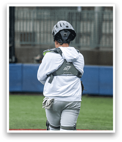 A young boy wearing a baseball uniform stands on a baseball field. AI generated content