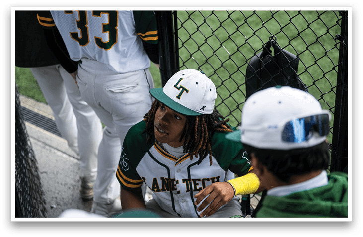 A baseball player wearing a green and white uniform is sitting on the ground. AI generated content