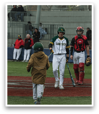 A baseball player wearing a green helmet and white uniform walks away from home plate while holding a bat. AI generated content