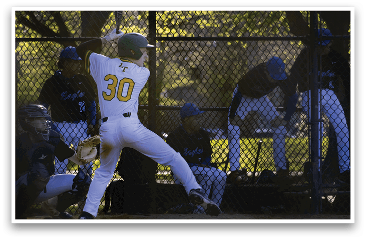 A baseball player in a green helmet and white uniform is swinging a bat. Description generated by AI