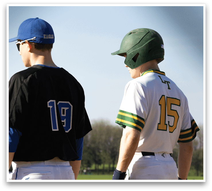 Two baseball players wearing helmets and uniforms. Description generated by AI