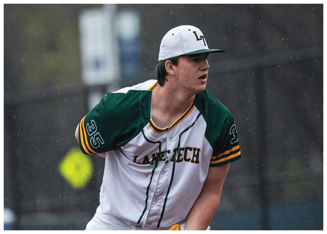 A baseball player in a white uniform with a green and yellow logo on the front. Description generated by AI