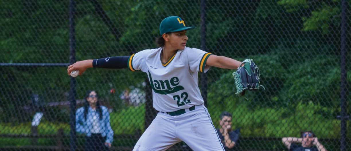 A baseball player in a green and yellow shirt is pitching a ball. Description generated by AI