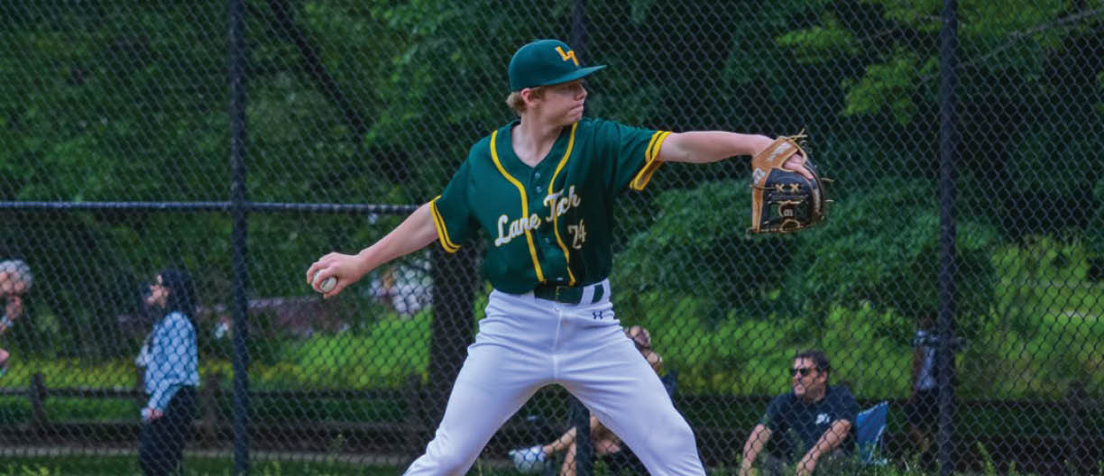 A baseball player in a green and yellow jersey is pitching a ball. Description generated by AI
