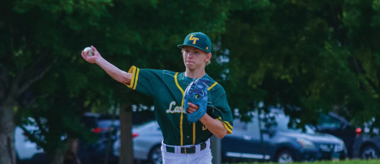 A baseball player in a green and yellow uniform is throwing a ball. Description generated by AI