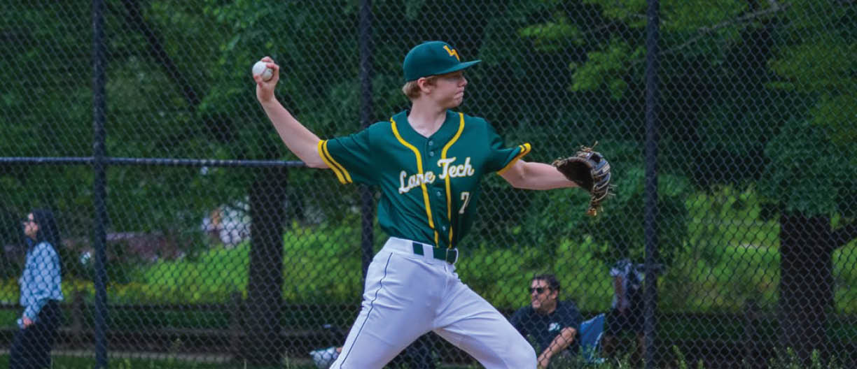 A baseball player in a green and yellow uniform is pitching a ball. Description generated by AI